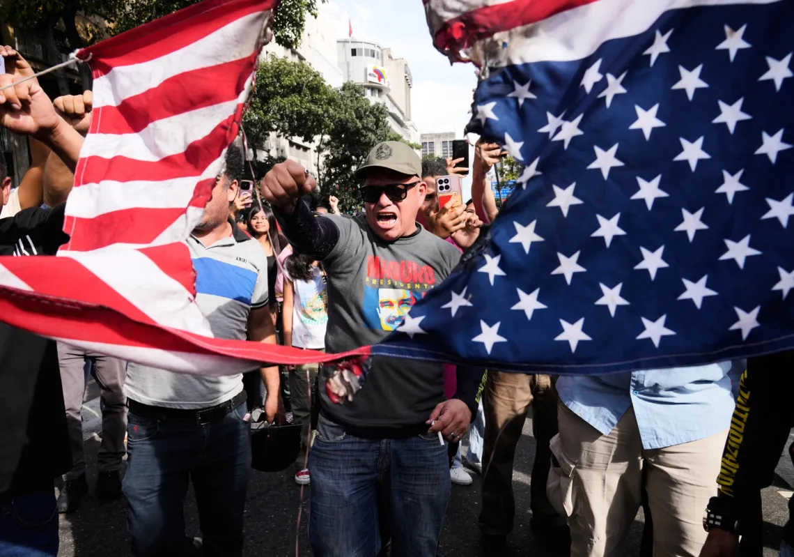 فنزويليون يمزقون العلم الاميركي اثناء احتجاج في كاراكاس في 3 يناير 