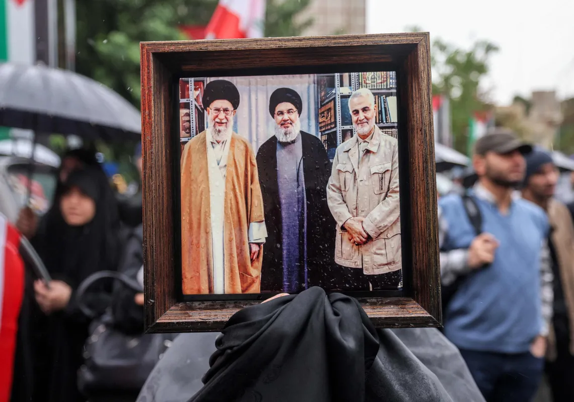 An Iranian holds a picture of Supreme Leader Ali Khamenei; Hezbollah leader Hassan Nasrallah, killed by an Israeli air strike on September 27, 2024; and Iran Quds Force Commander Qasem Soleimani, killed by the US in January 2020.