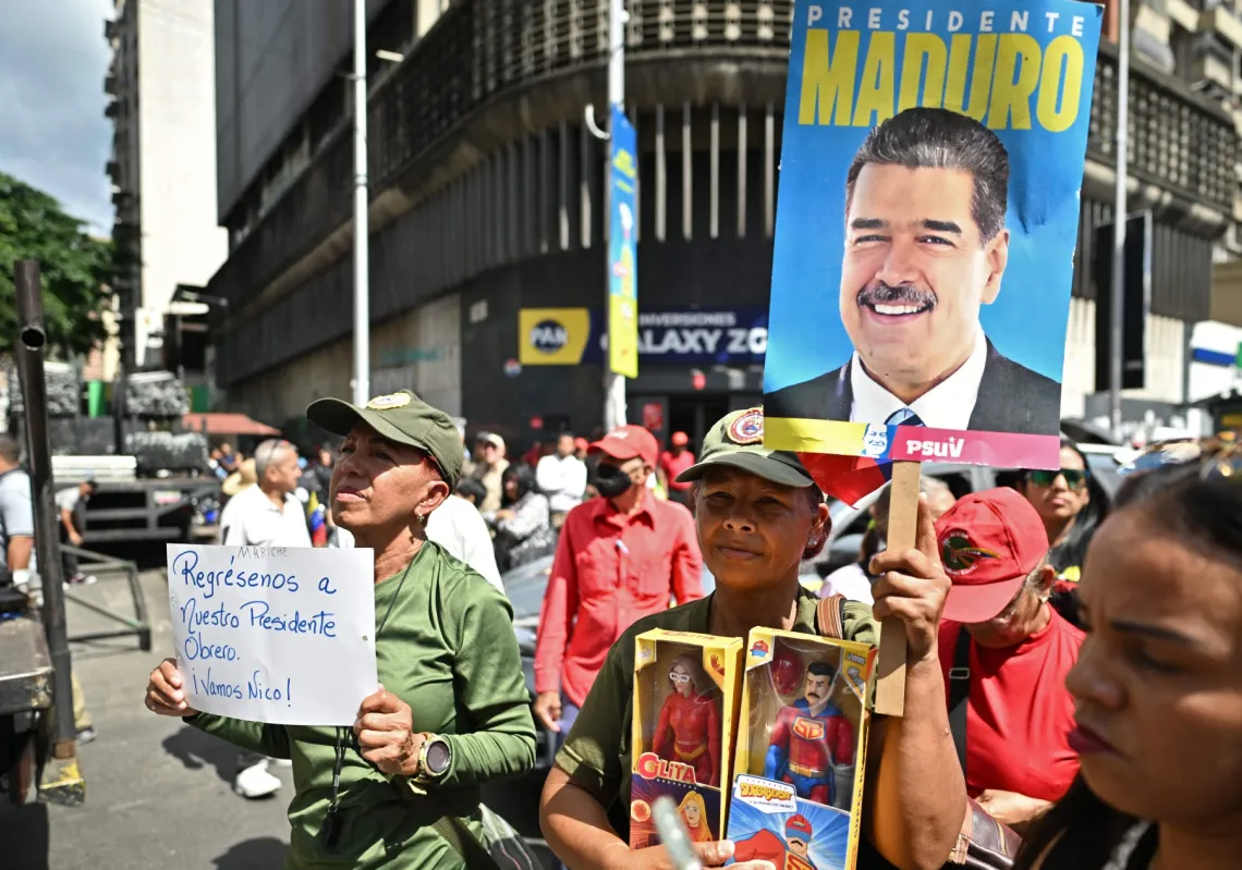 أحد مؤيدي الرئيس الفنزويلي نيكولاس مادورو يرفع لافتة كتب عليها "أعيدوا إلينا رئيسنا" خلال مظاهرة في كاراكاس في 4 يناير 2026