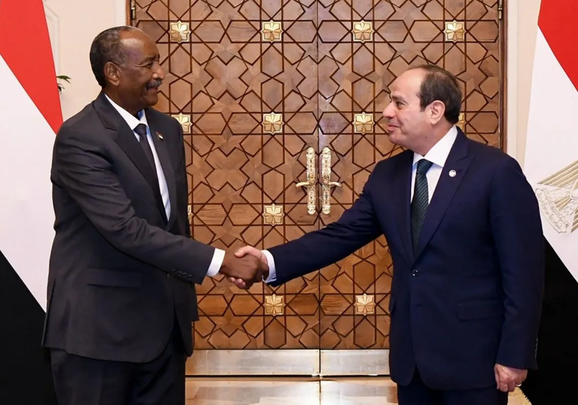 Egyptian President Abdel Fattah al-Sisi (R) shakes hands with Sudan's army chief General Abdel Fattah al-Burhan in Cairo on 18 December 2025.