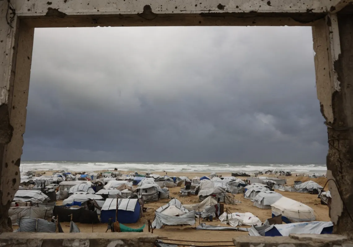 خيام تؤوي عائلات فلسطينية نازحة على شاطئ مدينة غزة، 13 يناير 2026، مع اشتداد الرياح الشتوية، في ظل دمار واسع خلّفته الحرب