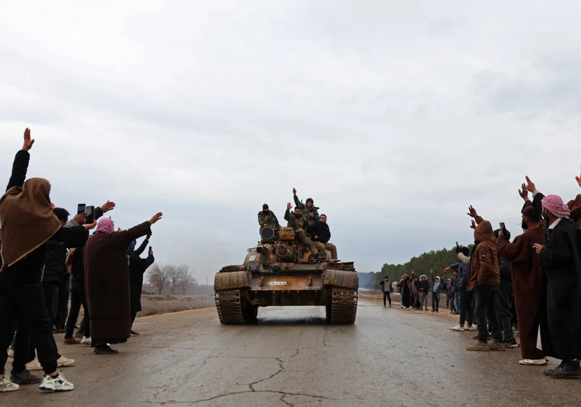 جنود سوريون يعتلون دبابة أثناء سيطرتهم على مواقع "قسد" بعد انسحابها من مسكنة، شمالي سوريا، في 17 يناير 2026