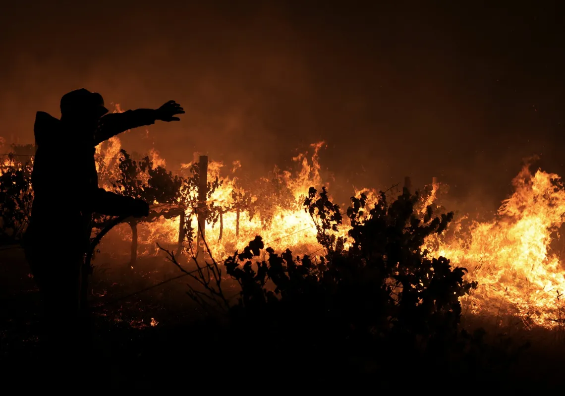 يعمل أحد رجال الإطفاء على إخماد حريق في منطقة فرانشوك، بمدينة كيب تاون، جنوب أفريقيا، في 21 يناير
