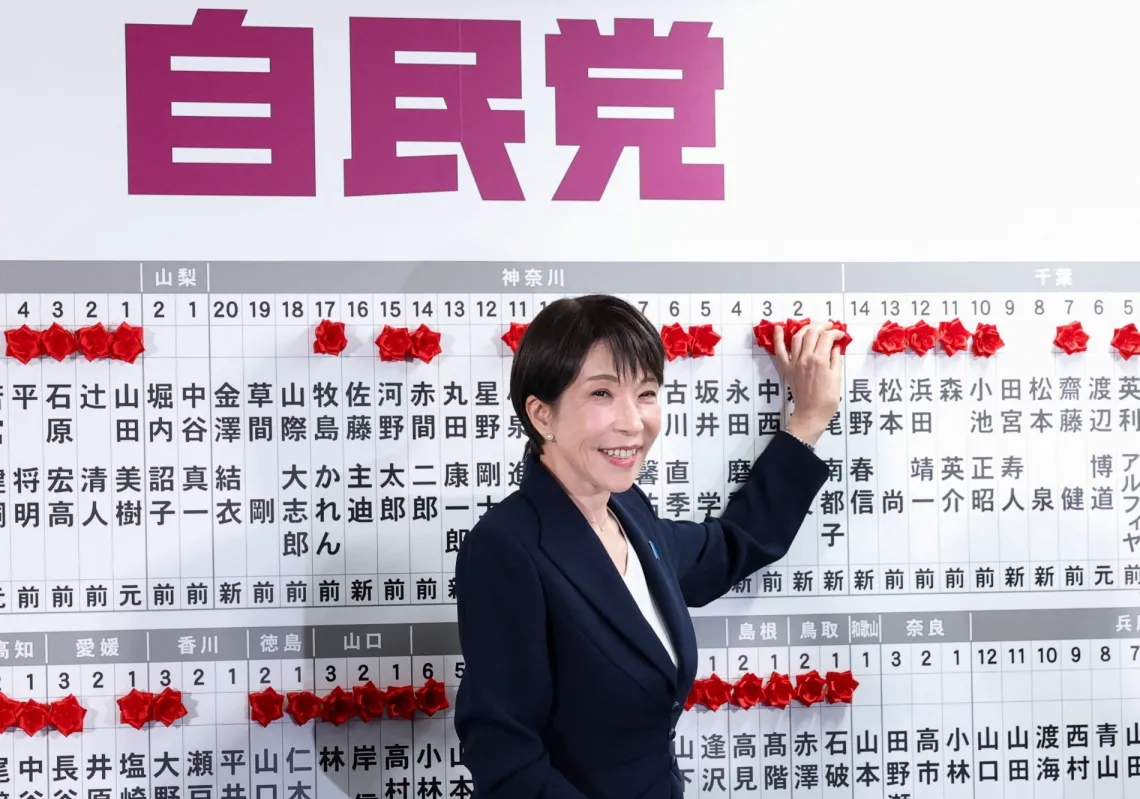 Japan's Prime Minister Sanae Takaichi, leader of the ruling Liberal Democratic Party (LDP), places a red paper rose on the name of an elected candidate at the LDP headquarters on general election day in Tokyo on 8 February 2026.
