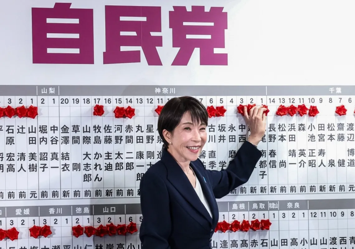 رئيسة وزراء اليابان ورئيسة "الحزب الديمقراطي الليبرالي" ساناي تاكايتشي تضع وردة ورقية حمراء على اسم أحد المرشحين الفائزين في مقر الحزب، 8 فبراير 2026