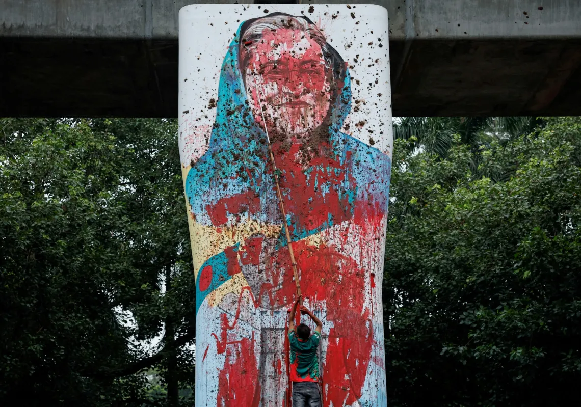 قام متظاهر بتخريب جدارية لرئيسة وزراء بنغلاديش، الشيخة حسينة، بالطلاء، مطالبا باستقالتها، وذلك في منطقة مركز المعلمين والطلاب بجامعة دكا في دكا، 3 أغسطس 2024