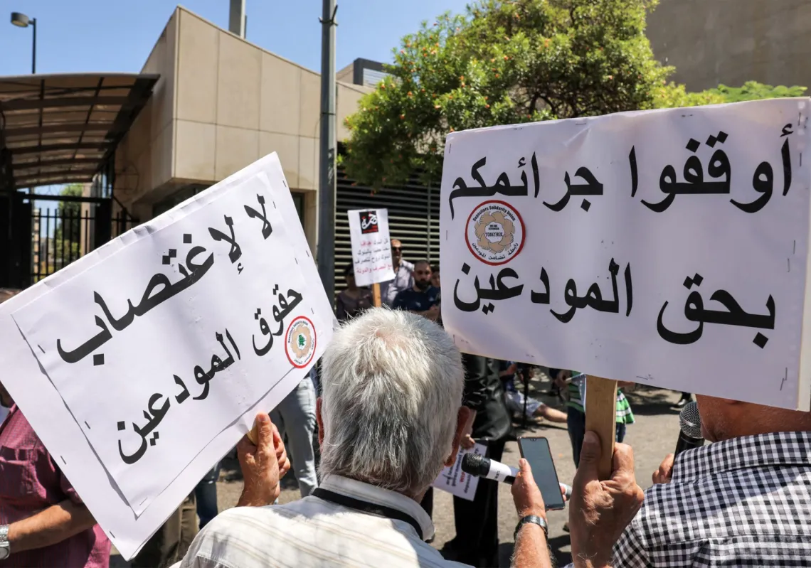 متظاهرون يرفعون لفتات تندد باختلاس أموال الموديعين، 23 يوليو 2023