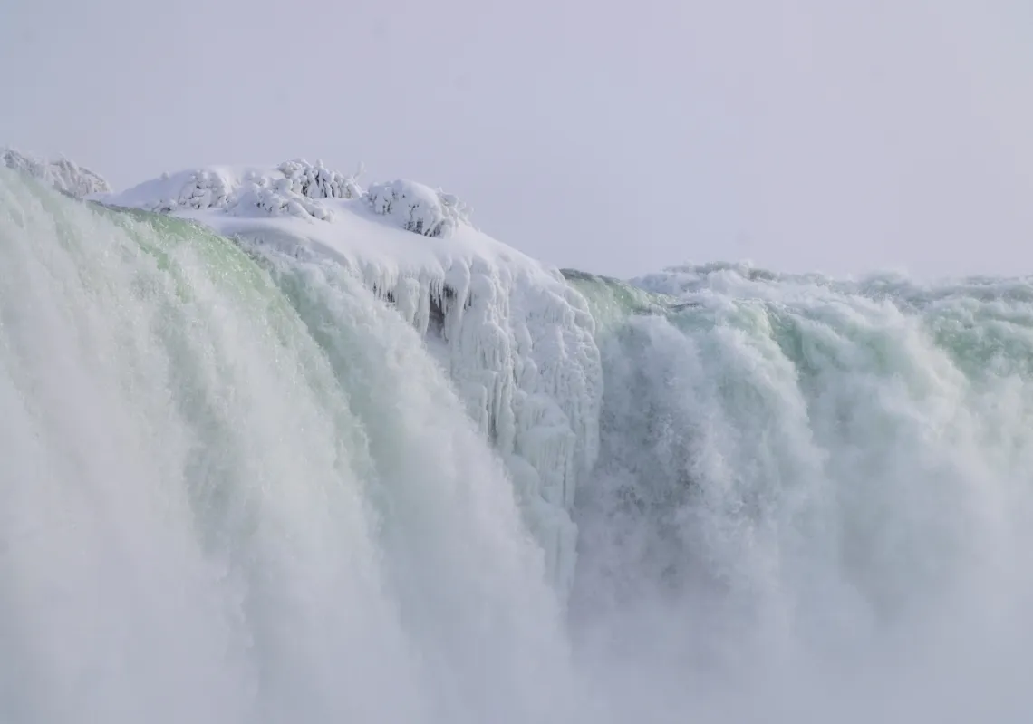 كتلة من الثلج والجليد تتدلى من حافة شلالات نياغرا المتجمدة جزئيا في نياغرا فولز، أونتاريو، كندا، 31 يناير
