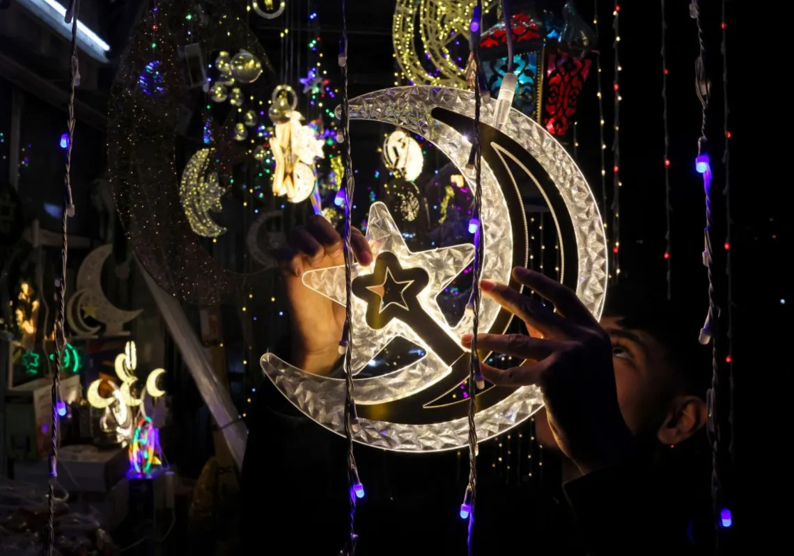 A Palestinian youth hangs decorative lights at a shop in East Jerusalem on 16 February 2026, as Muslims prepare for the holy fasting month of Ramadan.