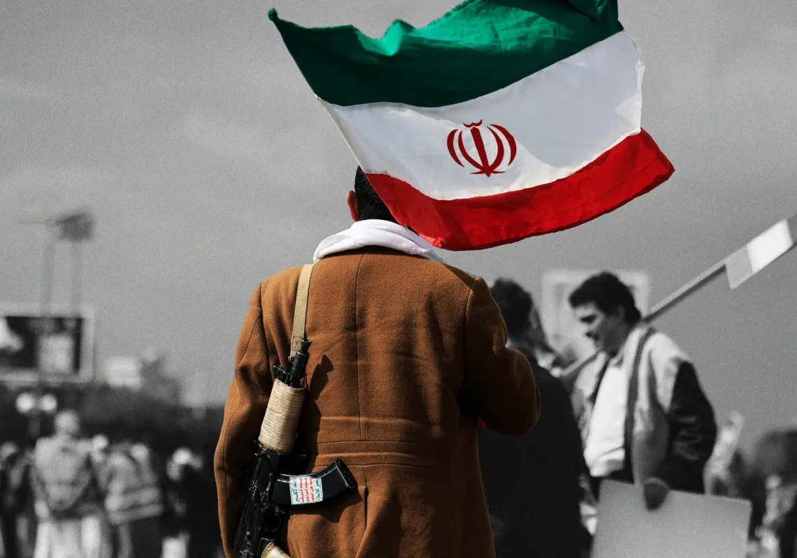 شخص يسير حاملاً العلم الإيراني خلال مظاهرة احتجاجية ضد إسرائيل والضربات الأميركية على إيران، في أعقاب اغتيال علي خامنئي، في صنعاء، اليمن، 1 مارس 2026
