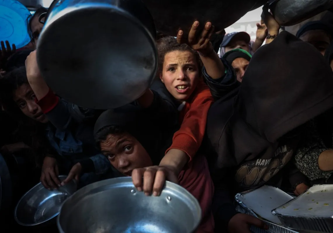 فلسطينيون ينتظرون الحصول على الطعام أمام مطبخ خيري في خان يونس جنوب قطاع غزة، 26 فبراير 2026، في ظل استمرار نقص الإمدادات واعتماد كثير من السكان على المساعدات الإنسانية