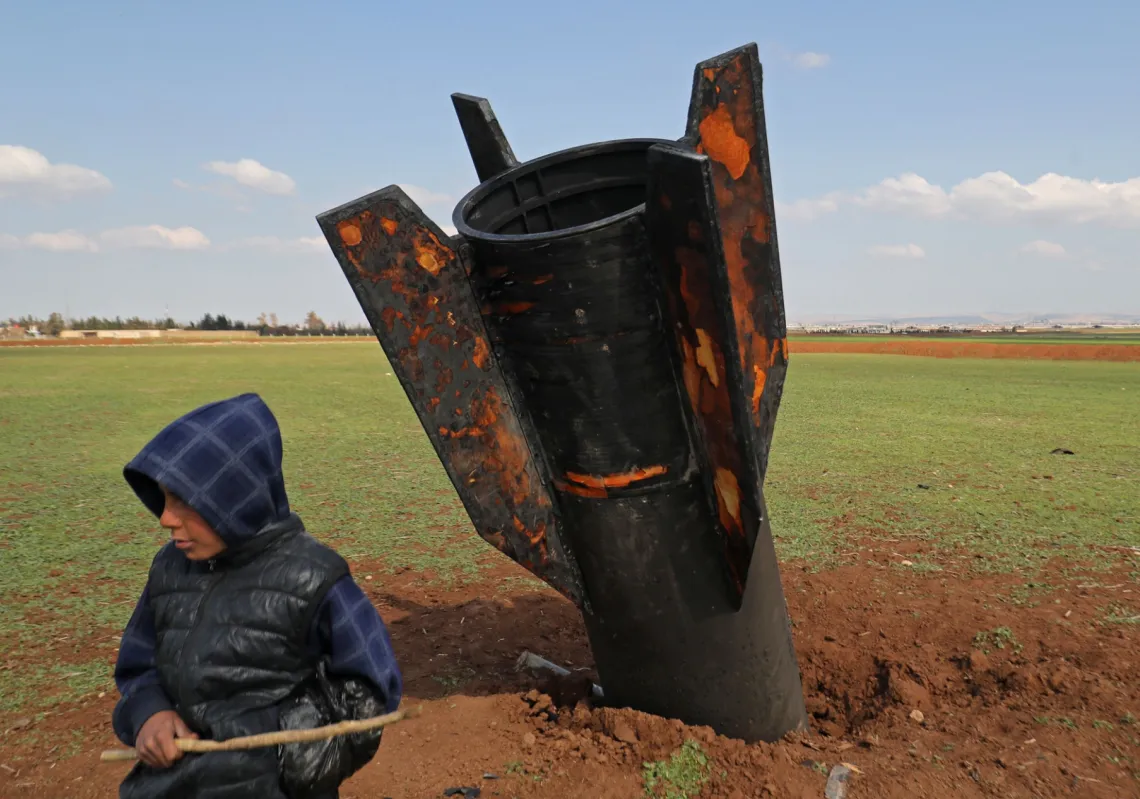 فتى يلهو بجوار صاروخ لم ينفجر سقط في حقل مفتوح على مشارف مدينة القامشلي، شرق سوريا، في 5 مارس 2026
