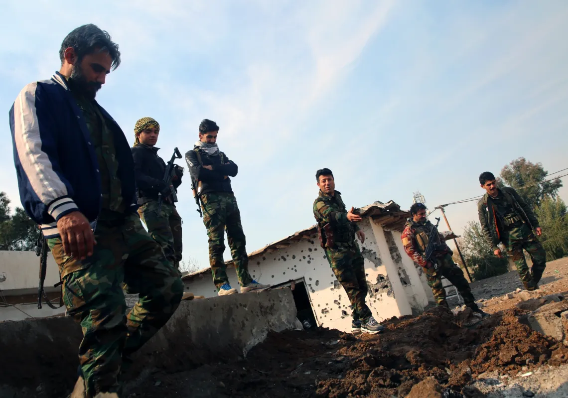 مقاتلون اكراد إيرانيون يعانون مكان انفجار صاروخ أطلق عليهم في المعسكر