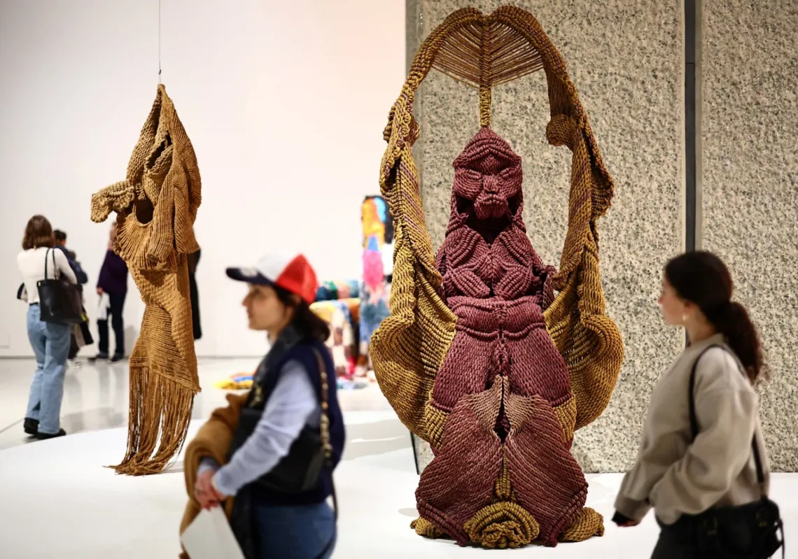 زوار يتأملون العمل الفني، "فانشري"، للفنانة الهندية مريناليني موخيرجي خلال معاينة صحافية لمعرض "تفكيك: قوة وسياسة النسيج في الفن"، مركز باربيكان بلندن، 12 فبراير 2024