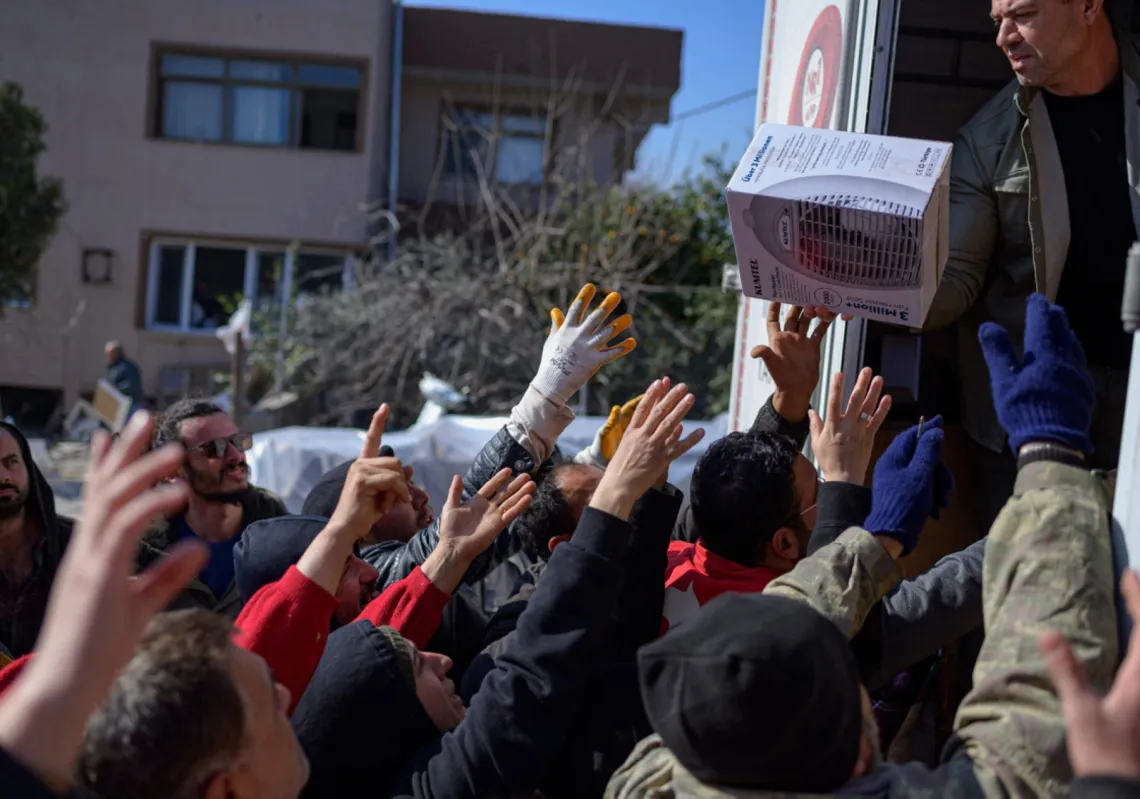 سكان يتدافعون للحصول على طعام وملابس وأدوات منزلية من شاحنة مساعدات في سامنداغ بجنوب هاتاي، 16 فبراير 2023، بعد عشرة أيام من الزلزال المدمر الذي ضرب الحدود التركية السورية