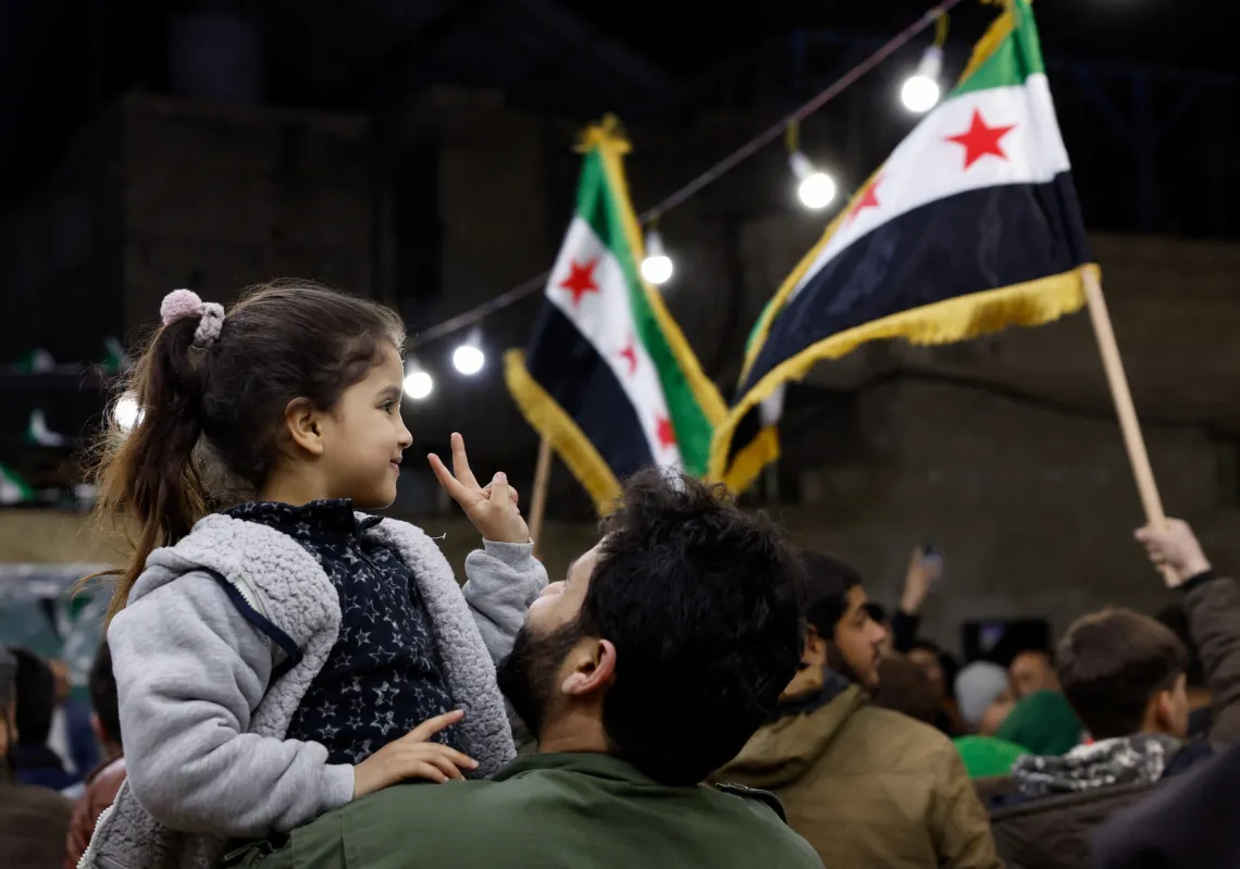 A girl shows a peace sign, as Syrians gather to mark the anniversary of the 2011 uprising against the ousted President Bashar al-Assad in Damascus, Syria, on 15 March 2026.