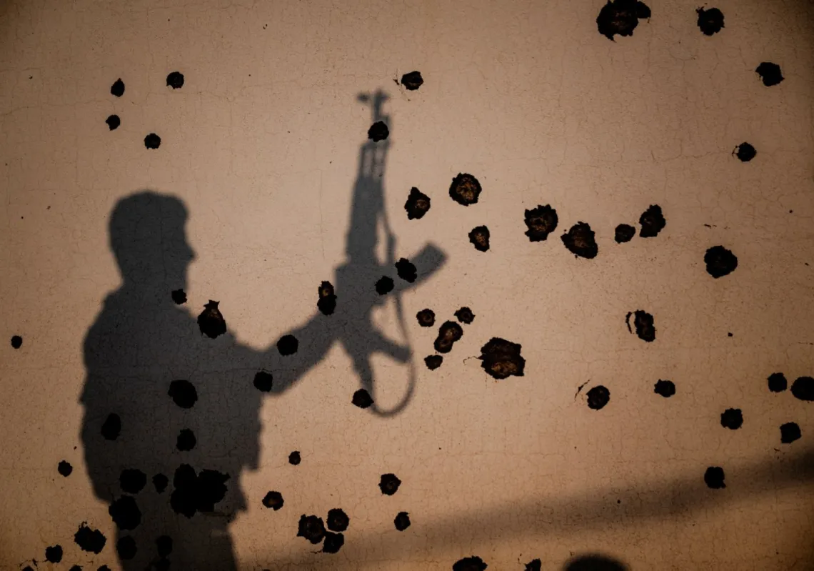 
مقاتلون أكراد، أعضاء في منظمة "النضال الكردي الإيراني" (سازماني خبات)، أمام جدار متضرر، في أعقاب هجوم بطائرة إيرانية على قاعدتهم القريبة من أربيل، في منطقة كردستان العراق ذات الحكم الذاتي في 9 مارس 2026