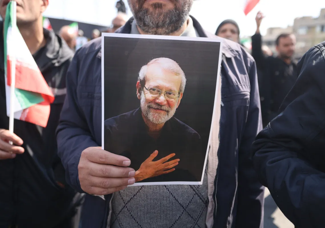 
يحمل أحد المشيعين صورة رئيس جهاز الأمن الإيراني علي لاريجاني خلال جنازته إلى جانب غلام رضا سليماني، وهو ضابط كبير في "الحرس الثوري" يقود قوات الباسيج، في طهران في 18 مارس 2026