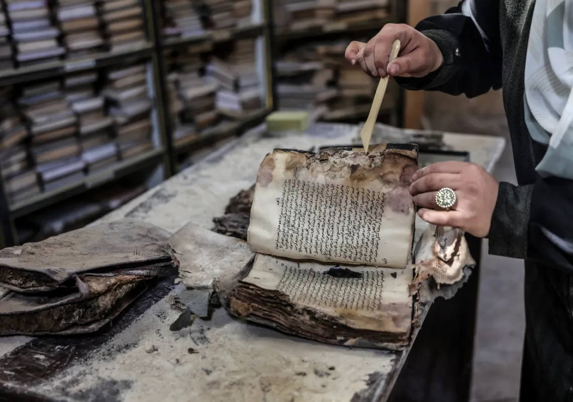 A Palestinian volunteer works to rescue and restore damaged books and manuscripts inside the library of the Great Omari Mosque in Gaza City, on 26 February 2026.
 