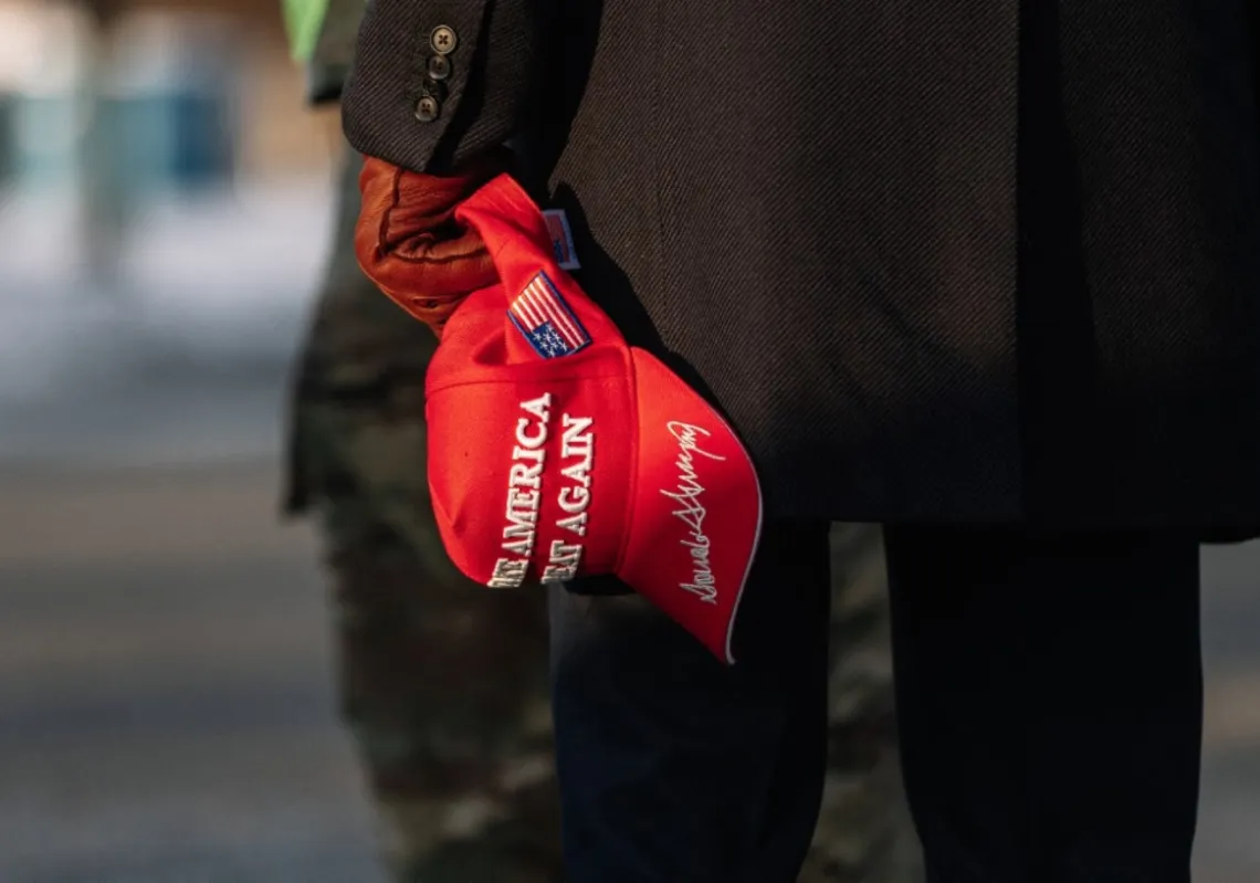 Trump holding a Make America Great Again Hat 