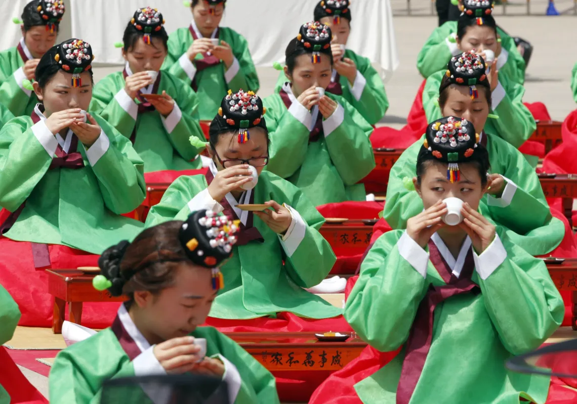 يحتسي المشاركون الشاي خلال مراسم يوم بلوغ تقليدية في سيول، 16 مايو 2011، فتمثّل المناسبة دخول الفتيان والفتيات سن الرشد عند العشرين وتذكيرهم بمسؤولياتهم الفردية