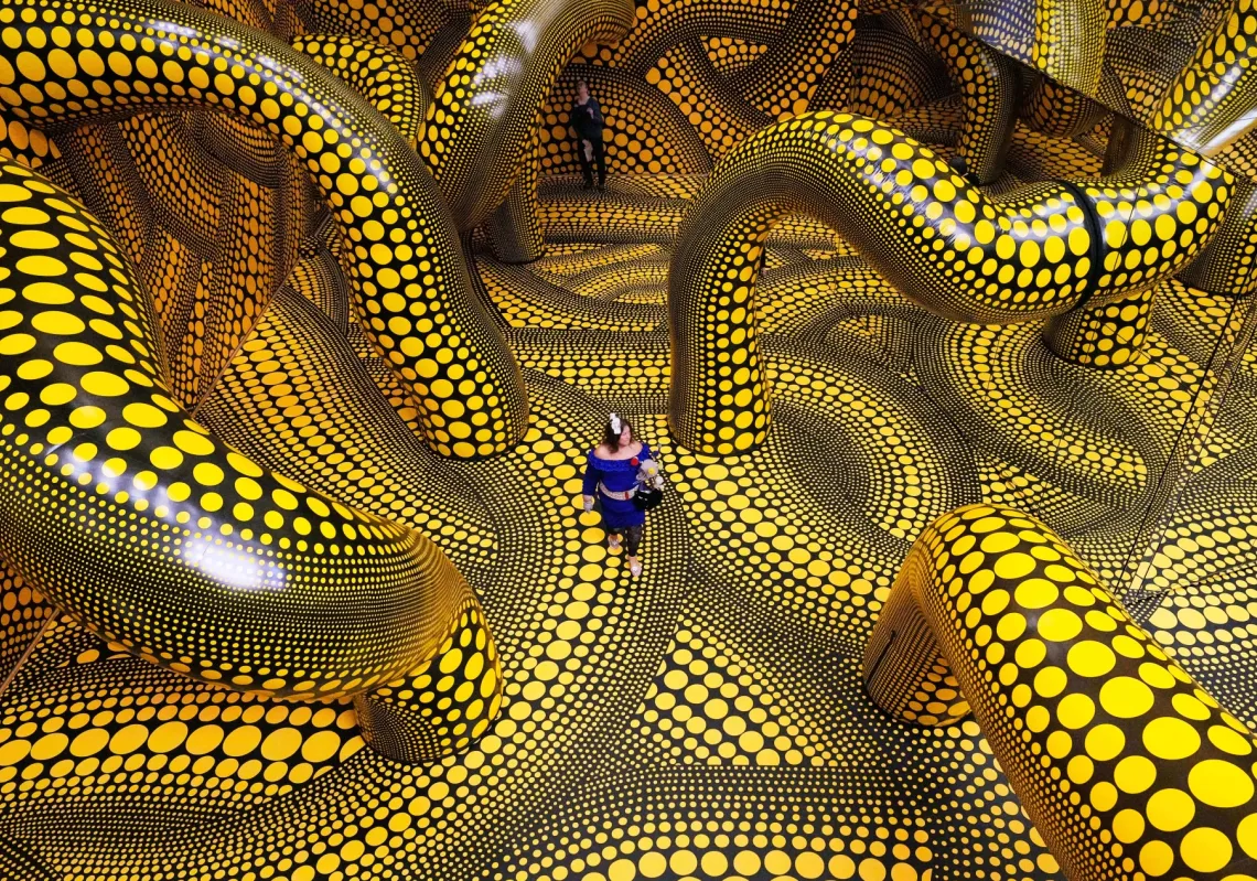 People walk through the artwork 'Infinity Mirrored Room' during a preview of the new major exhibition of legendary Japanese artist Yayoi Kusama at the Museum Ludwig in Cologne on 12 March 2026. 