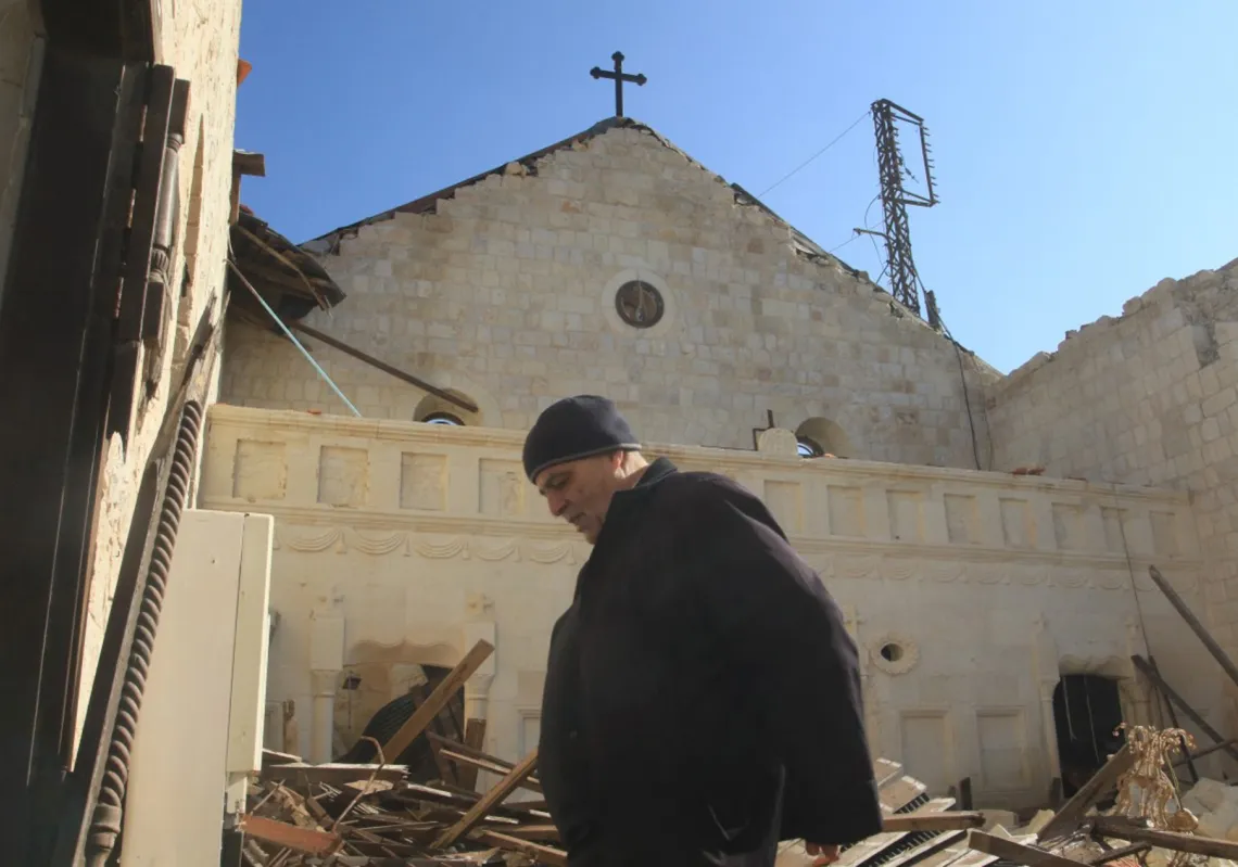  أحد المصلين يسير داخل كنيسة مار جرجس المتضررة بشدة، خلال قداس عيد الميلاد في قرية يارون جنوب لبنان قرب الحدود مع إسرائيل، في 25 ديسمبر 2025