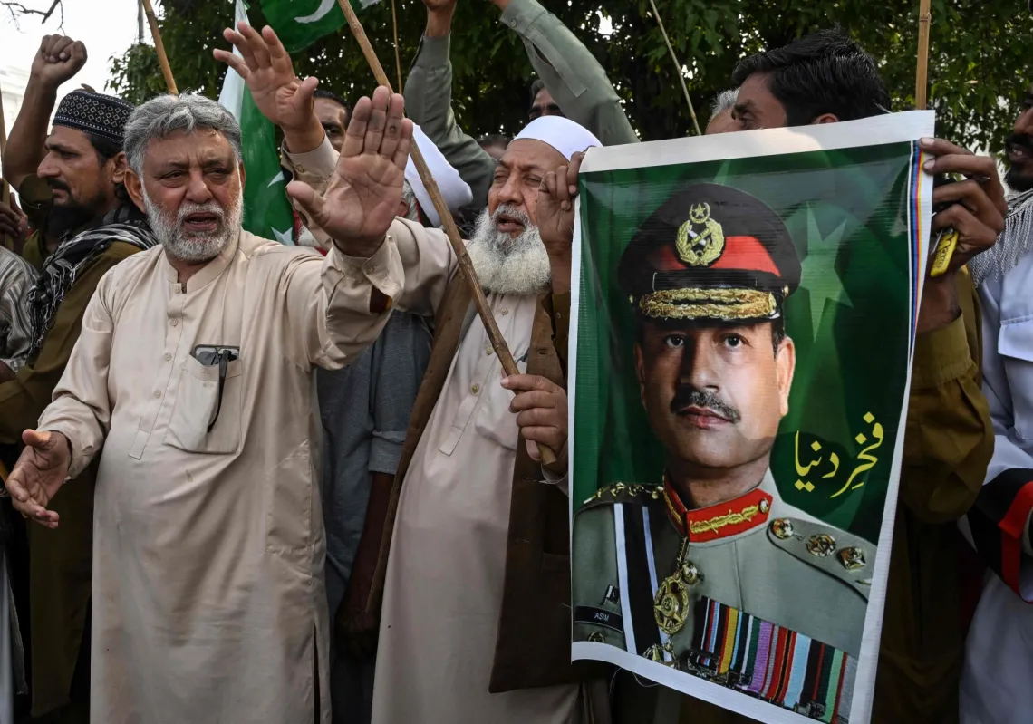 Awami Rickshaw Union workers holding posters of Pakistan's Chief of Army Staff, Field Marshal Asim Munir, shout slogans after the US and Iran agreed to a two-week ceasefire in Lahore on 8 April 2026. 