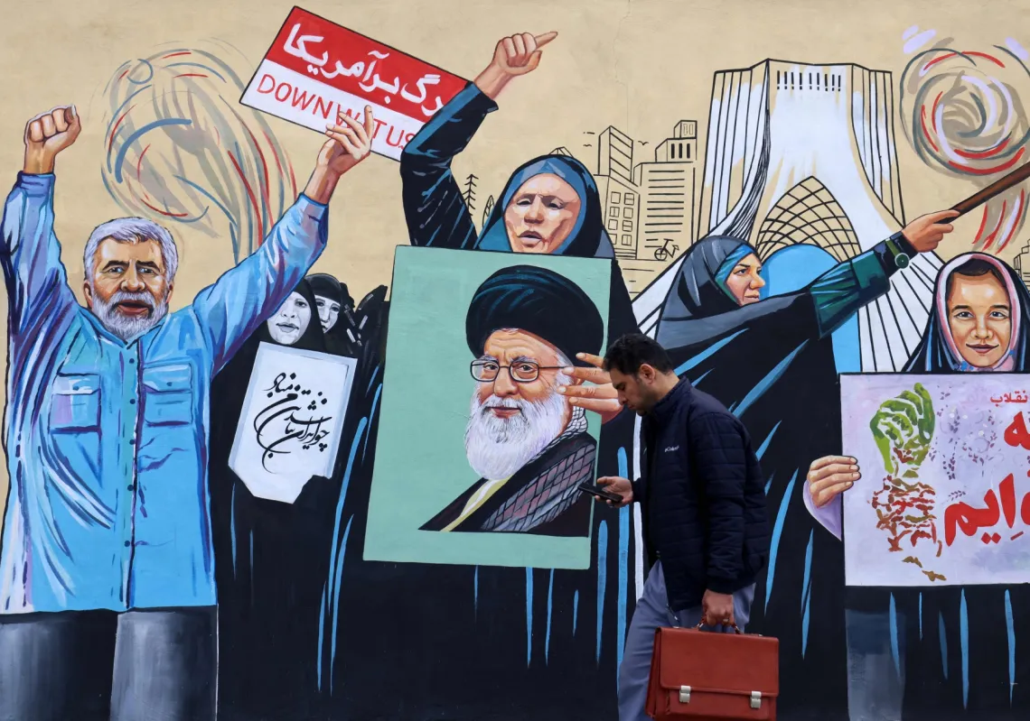 A man walks past an anti-USA and anti-Israel mural in Tehran on 8 April 2026.