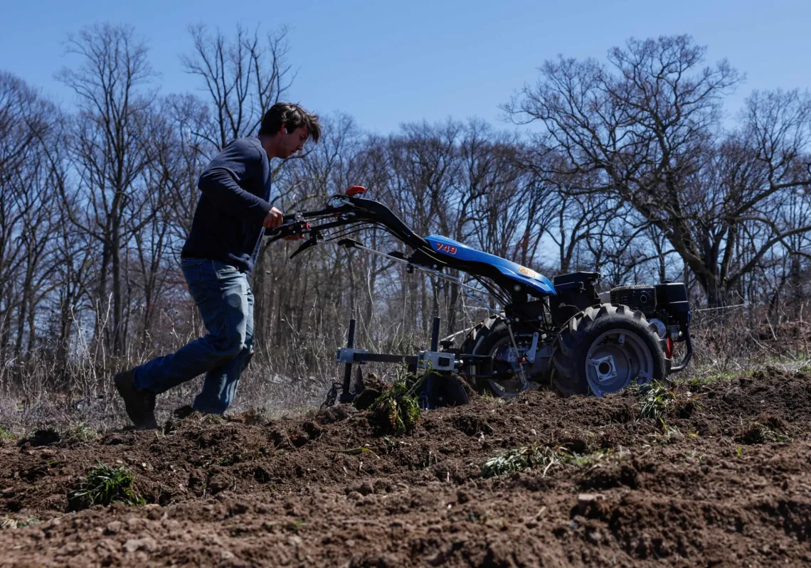 مزارع يقود جرارا صغيرا يعمل بالبنزين في مزرعة بنيويورك، وسط انشغاله بارتفاع أسعار الوقود رغم اعتماد الزراعة المستدامة، 8 أبريل 2026