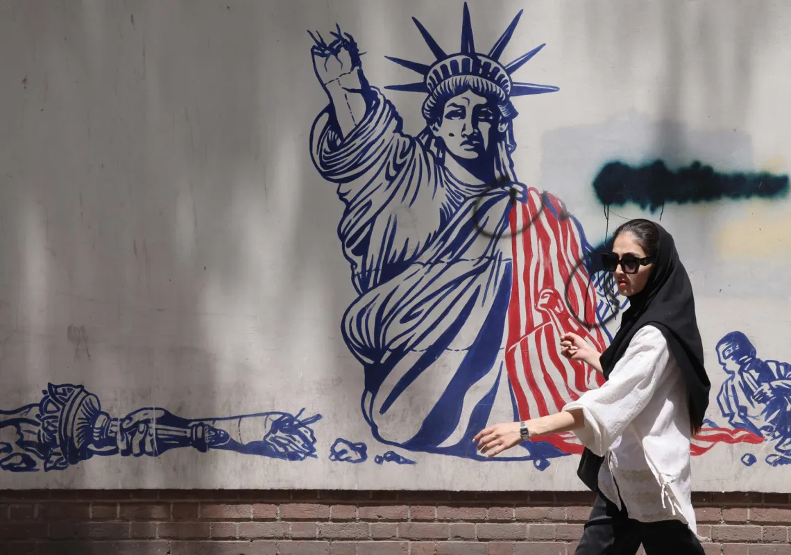 امرأة تمر أمام جدارية مناهضة للولايات المتحدة بالقرب من السفارة الأميركية السابقة في طهران