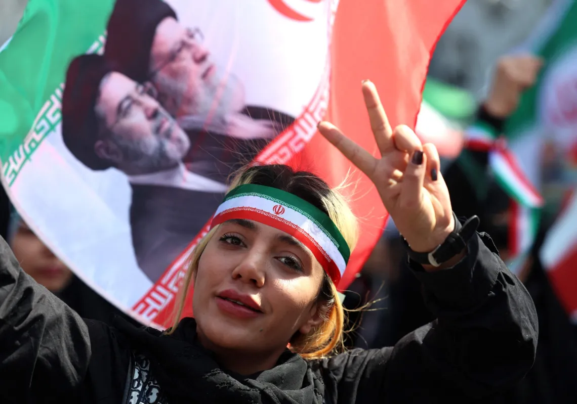 An Iranian woman flashes the V-sign as she takes part in a rally to pay tribute to women killed during war, in Tehran on 17 April 2026.