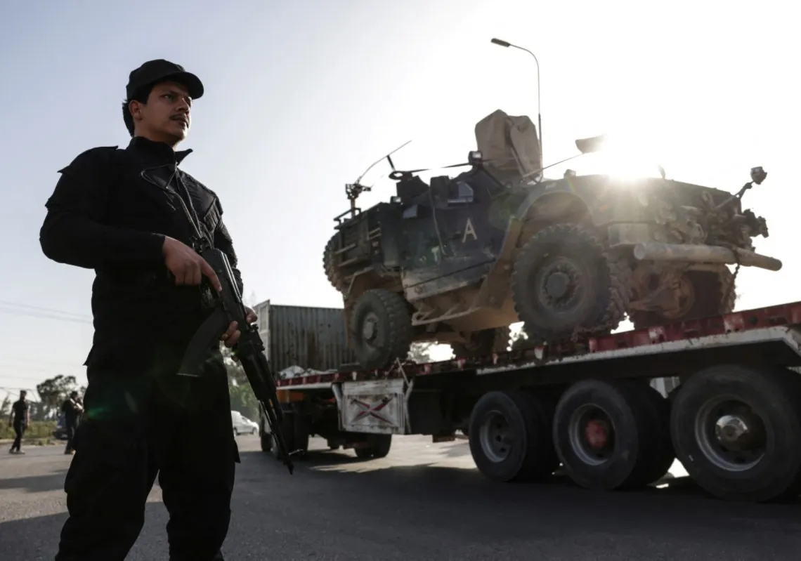 Syrian security stands guard as a convoy of US military equipment is transported along the Damascus–Amman highway as the US withdraws from its bases in Syria on 16 April, 2026.