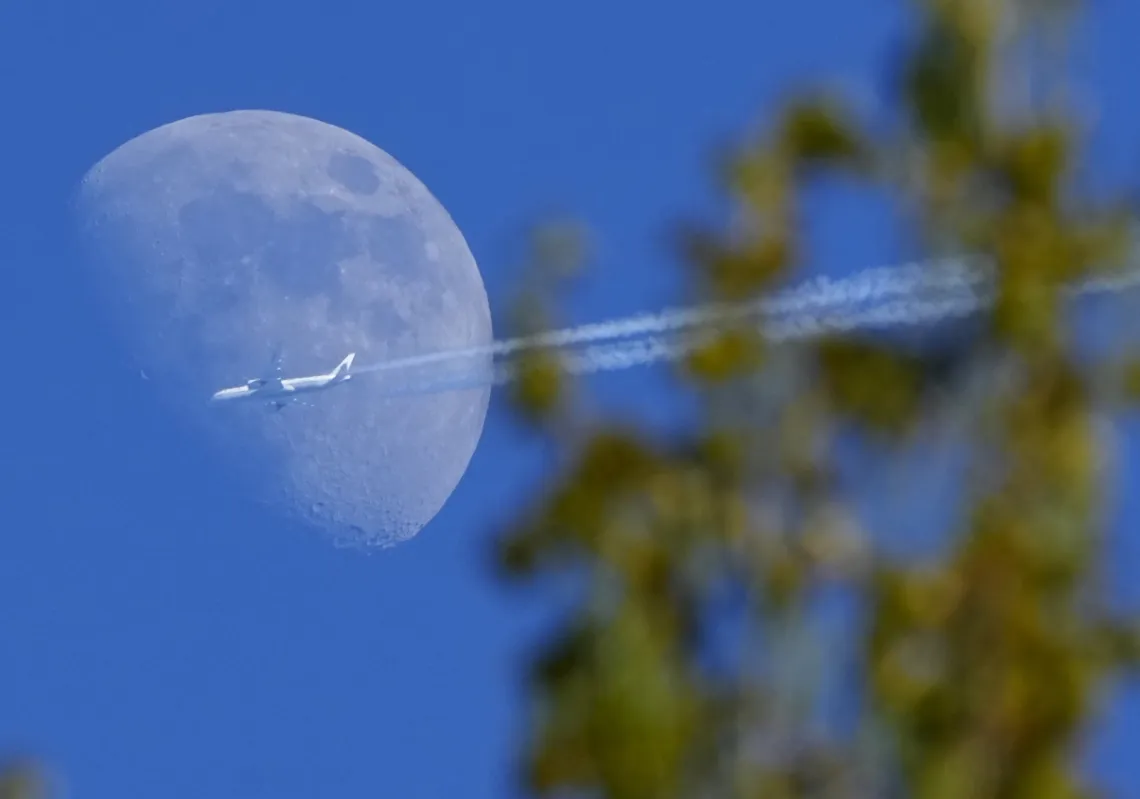 طائرة "بوينغ" طراز "787-9 دريملاينر" تابعة لشركة طيران الصين تحلق من مدريد في اتجاه بكين، أثناء تحليقها بجانب القمر فوق قرية بودلي، على بعد 70 كيلومترا شرق سان بطرسبرج، روسيا، الجمعة 17 مايو 2024.