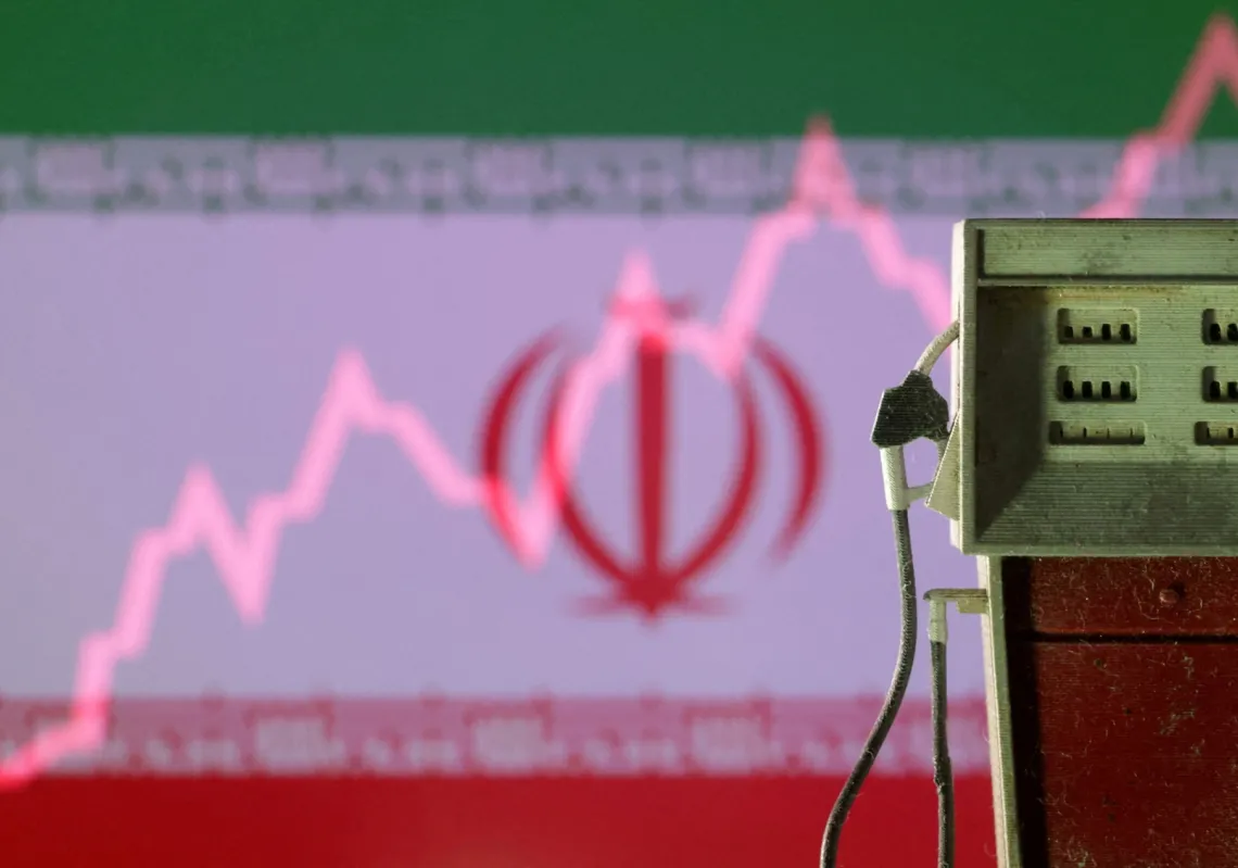 العلم الإيراني مع رسم بياني صاعد ومجسم مضخة وقود، 23 يونيو 2025، في إشارة إلى تقلبات الطاقة المرتبطة بإيران