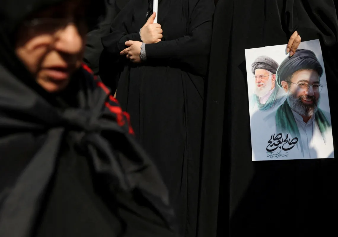 A woman holds an image of Iran's new supreme leader, Mojtaba Khamenei, alongside late Iranian Supreme Leader
Ayatollah Ali Khamenei. States have the resources, reach, and expertise to pursue their enemies.