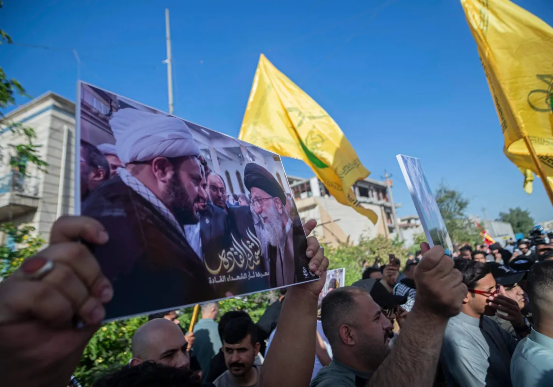
رفع رجل لافتة تحمل صور المرشد الإيراني علي خامنئي وأكرم الكعبي، الأمين العام لـ"حركة النجباء"، وهي فصيل مسلح موالٍ لإيران، خلال مظاهرة تضامنية مع أكرم الكعبي في بغداد في 8 مايو 2026