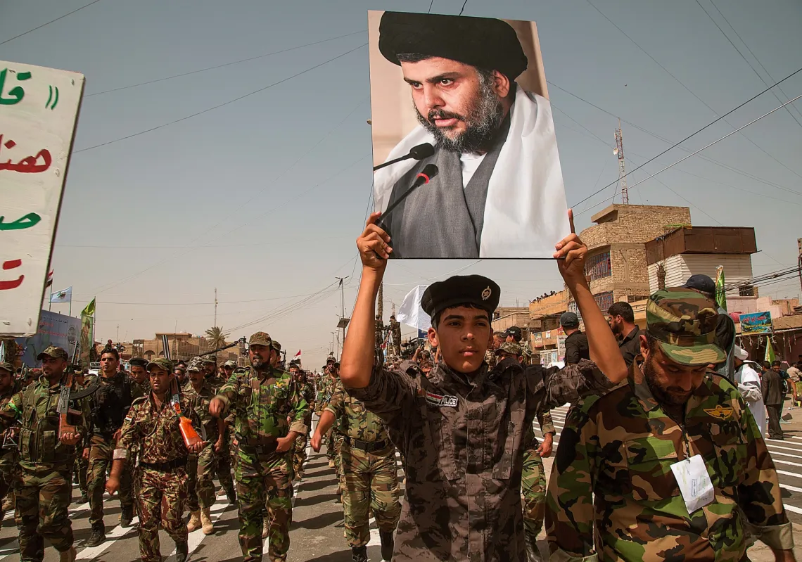 Units of Moqtada Sadr's militia parade with his photo down a main street of the Shiite stronghold of Sadr City June 21, 2014, in Eastern Baghdad.