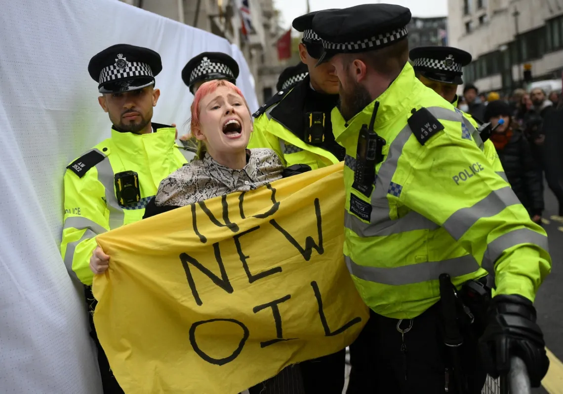 Police officers remove a climate activist protesting against the Rosebank oil field project in the North Sea off the coast of Scotland in central London on 18 October 2023. 