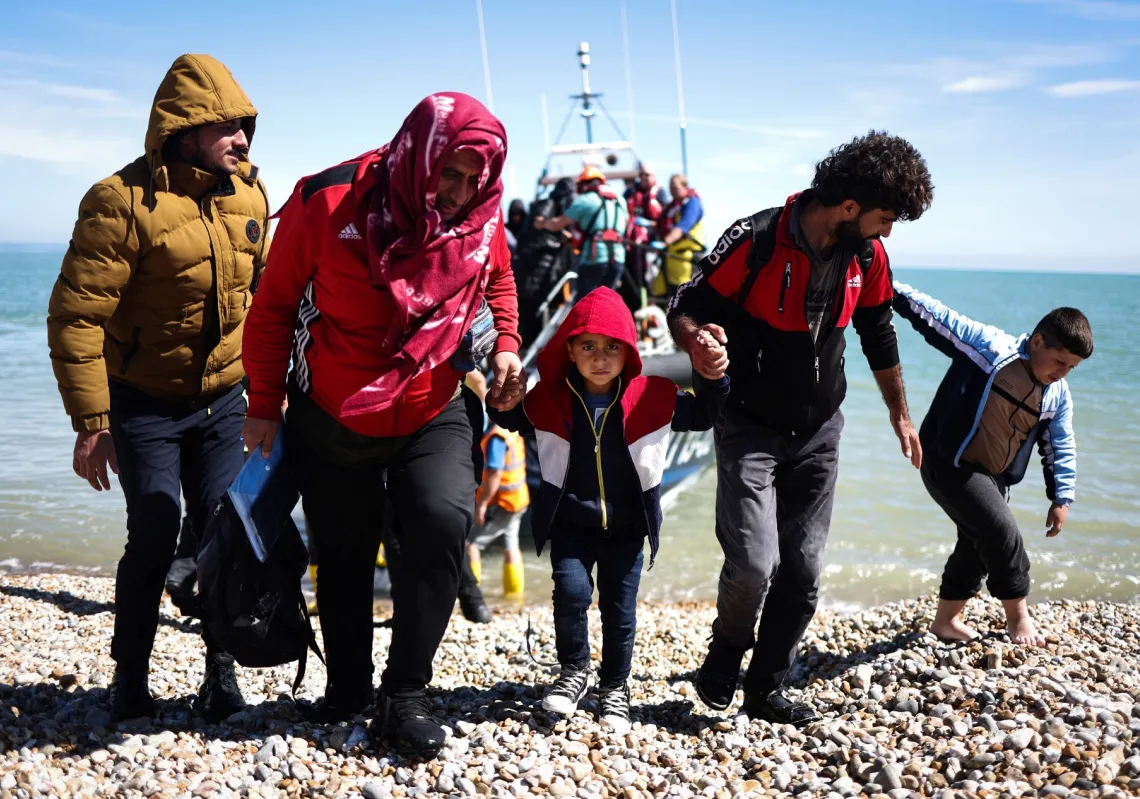 Migrants disembark from a lifeboat on the southeast coast of England after being picked up at sea while crossing the English Channel from France on 16 August 2023.