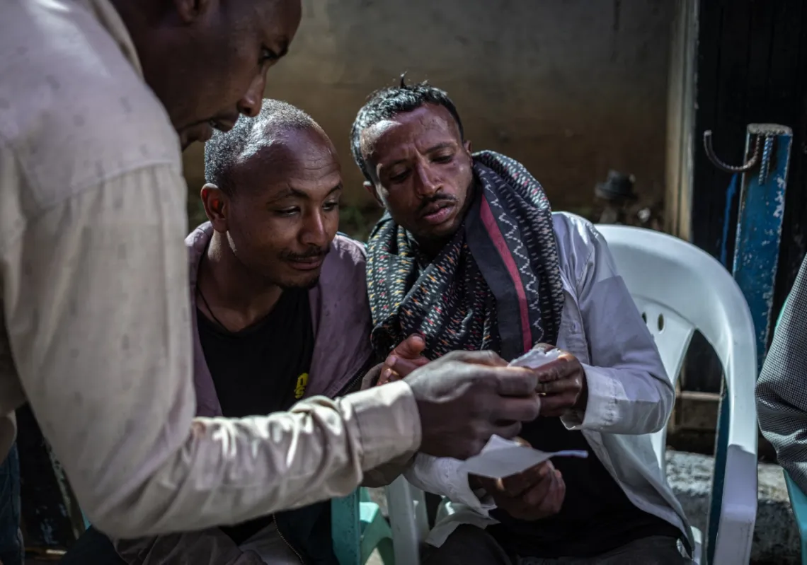 MARCO SIMONCELLI / AFP
Photo by MARCO SIMONCELLI / AFP
Voters check their voter registration cards outside Shalla Park polling station in Addis Ababa on 1 June 2026, during the 2026 Ethiopian parliamentary elections.