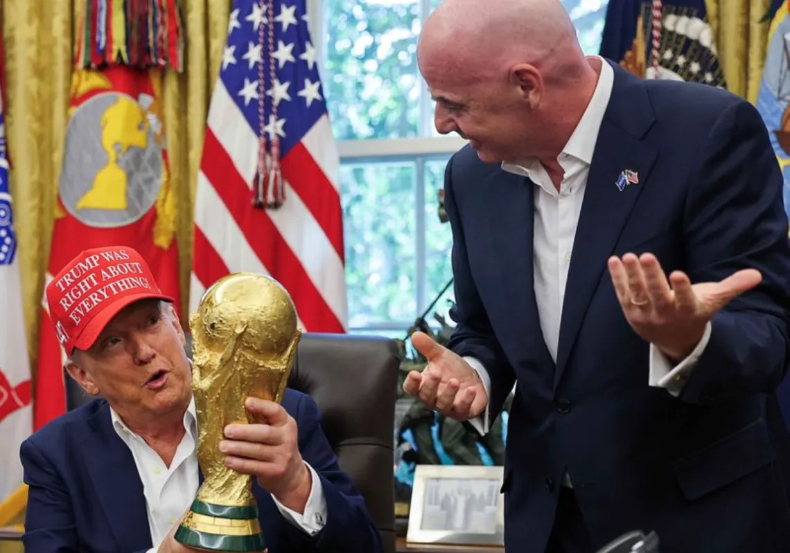 الرئيس الأمريكي دونالد ترامب يحمل كأس العالم لكرة القدم في المكتب البيضاوي بالبيت الأبيض في واشنطن في 22 أغسطس/آب 2025 بحضور جياني إنفانتينو