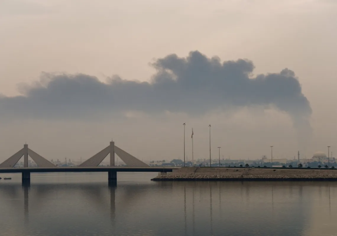 A plume of smoke rises after a reported Iranian strike on fuel tanks in Muharraq, Bahrain, on 12 March 2026.