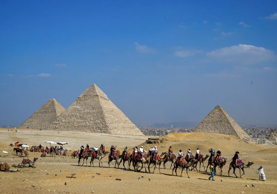 سياح يركبون الجمال أثناء جولة حول الأهرام، الجيزة 7 نوفمبر 2025