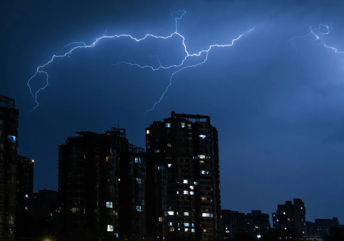 ومضات برق متشعبة تعبر السماء فوق المباني السكنية خلال عاصفة رعدية في بكين، الصين، 5 يوليو