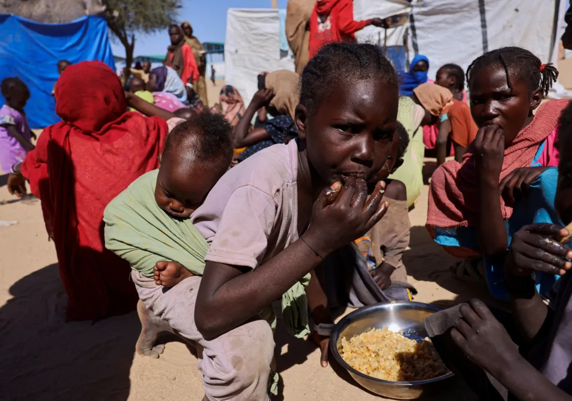 أطفال سودانيون لاجئون من الفاشر يتشاركون وجبة في مخيم تيني بشرق تشاد. 