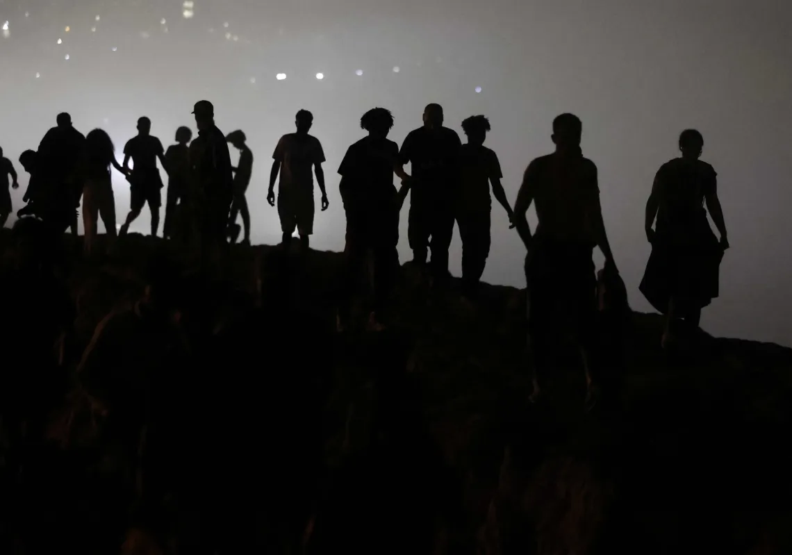 Migrants walk towards the Fnideq region in northern Morocco after leaving Spain's North African enclave of Ceuta following an attempted crossing at the Bab Sebta border crossing, on the outskirts of Fnideq, on 1 August 2026.