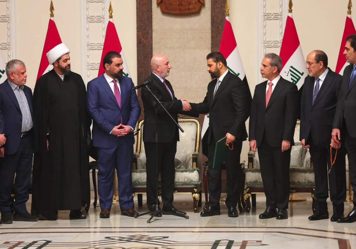 يظهر الرئيس العراقي نزار عبده مصافحاً رئيس الوزراء العراقي المكلَّف حديثا علي الزيدي وسط عدد من السياسيين العراقيين، في 27 أبريل 2026