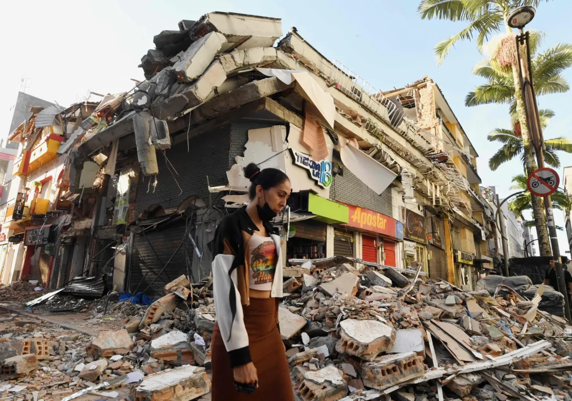 A woman walks past the rubble of a collapsed building after an earthquake in Pereira, Colombia on August 11, 2026. A magnitude 7.4 earthquake struck Colombia on 10 August 2026 and killed at least 111 people.