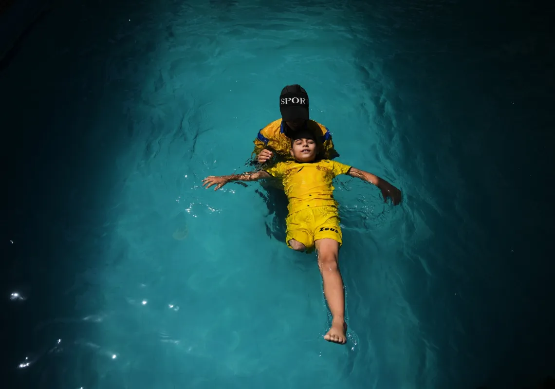 Palestinian girl Miral al-Babli, who lost a leg in Israel's war on Gaza, receives swimming training from the Heal Palestine organisation at a pool in Khan Younis, Gaza Strip, on 20 August 2026. 